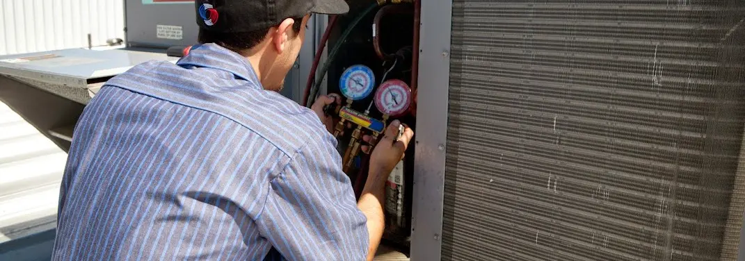 HVAC technician servicing a condenser unit in Martha Lake